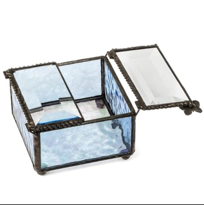 A small decorative glass storage box with a hinged lid, featuring textured light blue and white patterned glass panels set in dark metal frames, shown open on a white background.